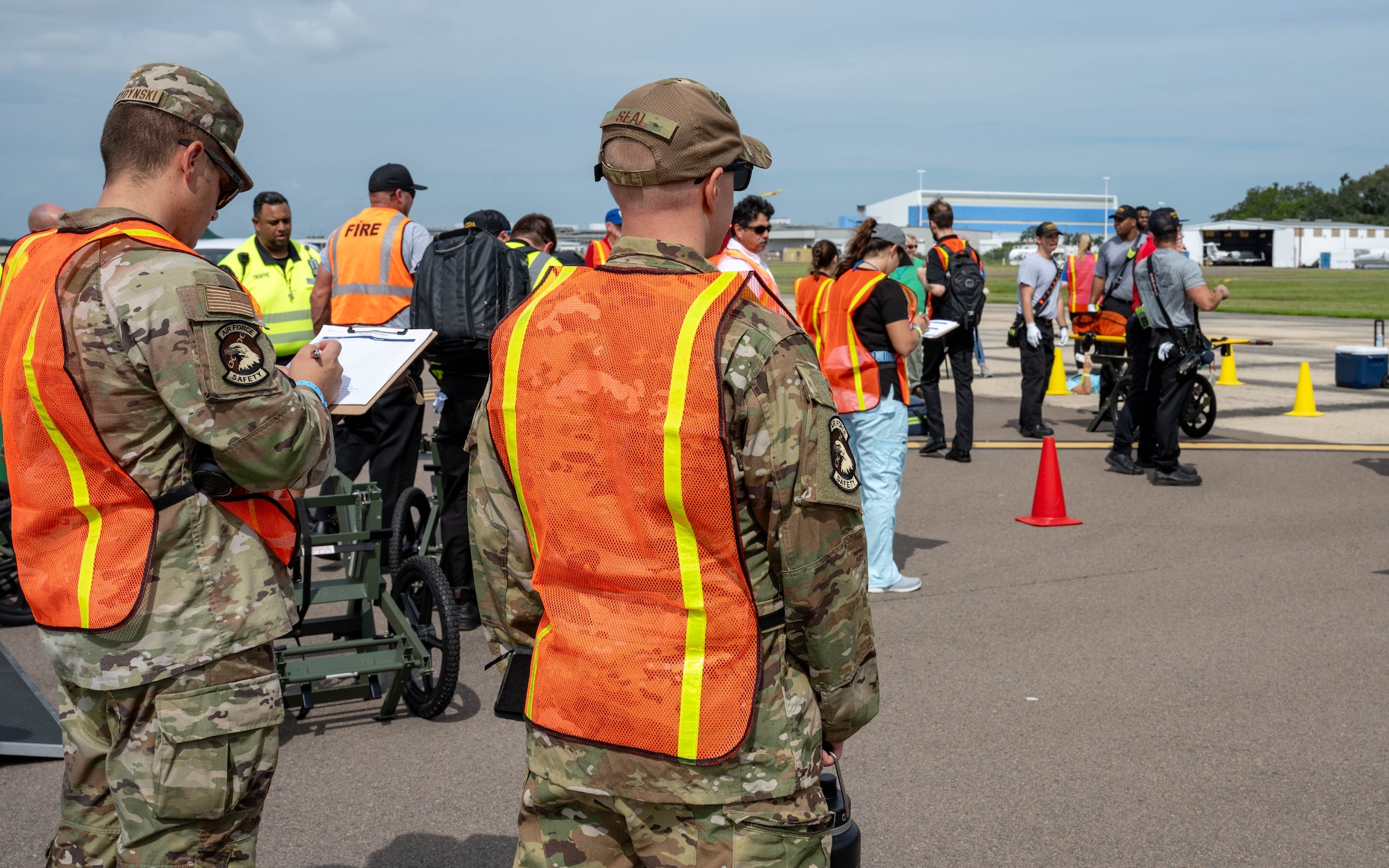 U.S. Air Force Lt. Col. Paul Seal, 6th Air Refueling Wing chief of safety, right, and Tech. Sgt. Adam Serdynski, 6th ARW flight safety non-commissioned officer, left, observe emergency response teams during the 2025 Triennial "Double Trouble" emergency response exercise at Tampa International Airport, Sept. 17, 2025. The flight safety team provided safety oversight alongside civilian agencies during a simulated aircraft emergency. (U.S. Air Force photo by Airman 1st Class Monique Stober)