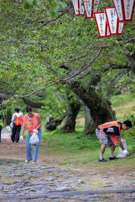 U.S. Marine Corps Cpl. Amanda Moreno, left, a food service specialist, and Sgt. Christian Lim, the food service manager for southside mess hall, both with Headquarters & Headquarters Squadron, Marine Corps Air Station Iwakuni, and natives of Florida, pick up trash alongside the riverbank during a clean-up at the Kintaikyo Bridge, Iwakuni, Japan, April 21, 2025. The Marine Corps Community Services Iwakuni, Single Marine Program hosted a bridge clean-up as part of the SMP Days of Service, a five-day series of events where service members from Marine Corps Air Station Iwakuni volunteer to build stronger relationships and give back to the community. (U.S. Marine Corps photo by Sgt. Randall Whiteman)
