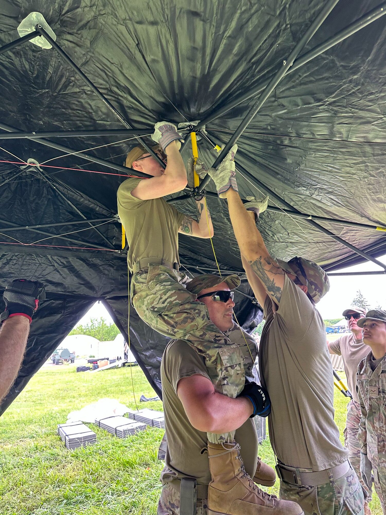 Airmen from the Kentucky Air National Guard’s 123rd Mission Support Group erect tent frames in Indiantown Gap, Pa., May 22, 2025, as part of Exercise Kentucky Windage 2025. Nearly 70 Airmen deployed for the field exercise to strengthen their Agile Combat Employment skills. (U.S. Air National Guard photo by Master Sgt. Kenneth Soto)