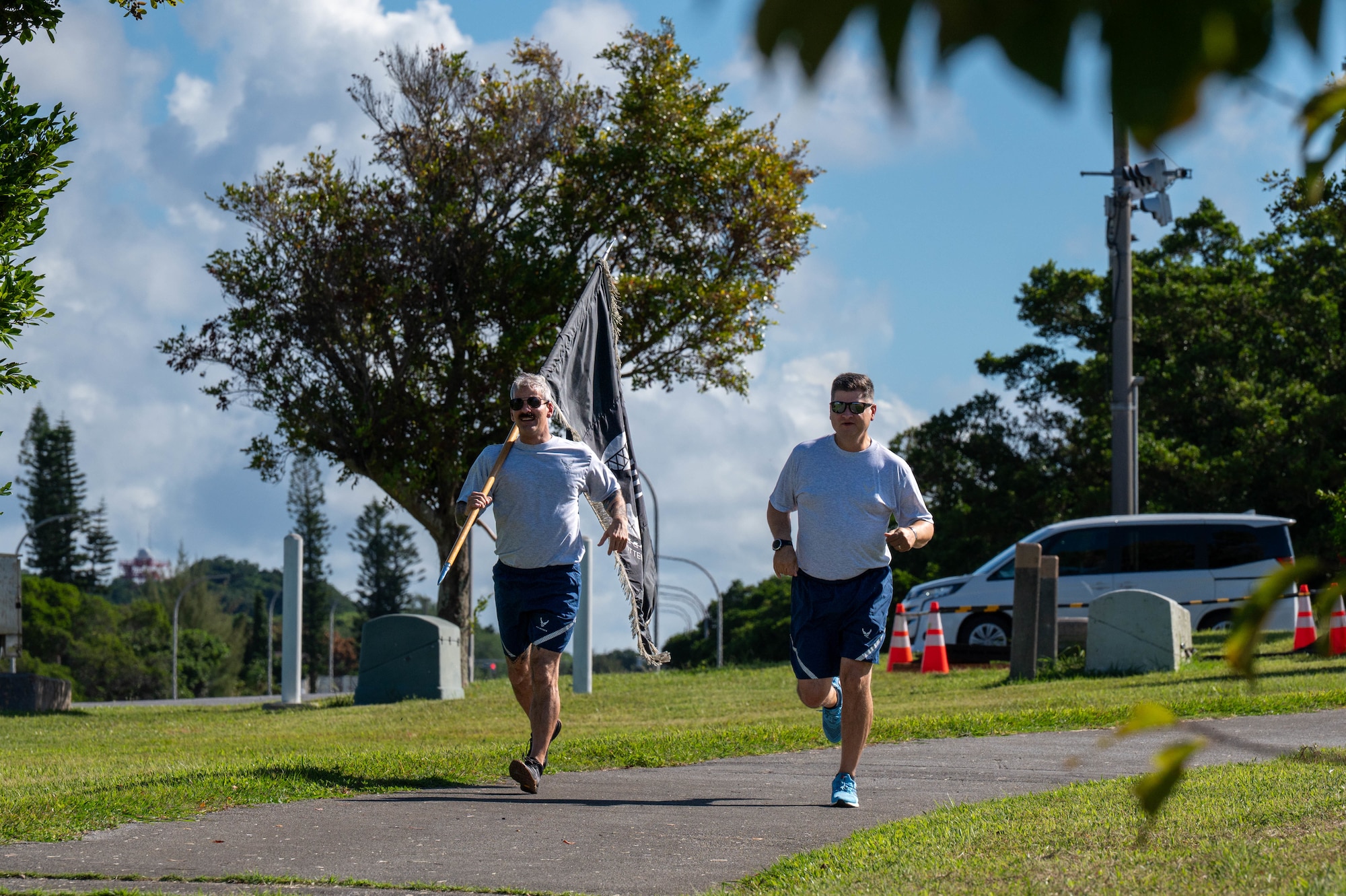 U.S Air Force Col. Gerald Carisio, 18th Maintenance Group commander, right, and Chief Master Sgt. James Toombs, 18th Maintenance Group superintendent, run the first lap during the opening ceremony of the POW/MIA Remembrance Run 24-hour ruck at Kadena Air Base, Japan, Sept. 18, 2025. Service members from across Kadena gathered to pay tribute, demonstrating unity while honoring the sacrifice of those who were captured or remain missing in action. (U.S. Air Force photo by Senior Airman Jamal Berry II)
