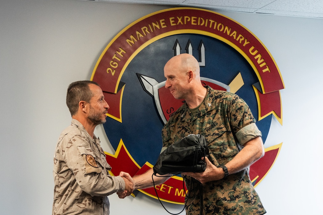 U.S. Marine Corps Col. Ben Reid, right, the commanding officer of the 26th Marine Expeditionary Unit, presents a gift to Teniente Coronel Emerito Pablo Alvarez Leon, a battalion commander with Infantería de Marina (Spanish marine corps) during exercise UNITAS 2025 at Marine Corps Base Camp Lejeune, Sept. 27, 2025. UNITAS, which is Latin for “unity,” was conceived in 1959 and has taken place annually since first conducted in 1960. This marks the 66th iteration of the world’s longest running annual multinational maritime exercise. (U.S. Marine Corps photo by Cpl. Osmar VasquezHernandez)