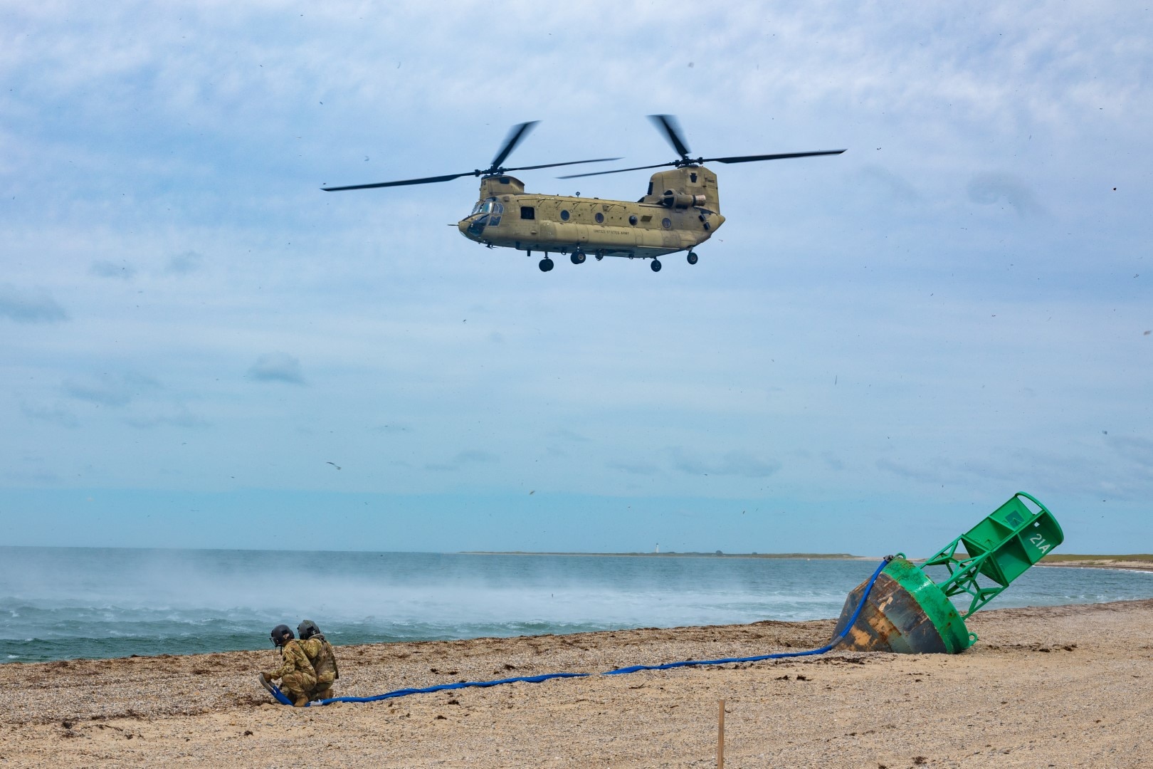 Connecticut Army National Guard Staff Sgt. Frank Perrotti, left, and Connecticut Army National Guard Sgt. 1st Class Richard Wooten, right, crew chiefs assigned to the 1109th Theater Aviation Support Maintenance Group, prepare to attach a sling to a Connecticut Army National Guard CH-47F Chinook helicopter during a buoy recovery mission, Nantucket, Massachusetts, Sept. 8, 2025.