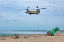 Connecticut Army National Guard Staff Sgt. Frank Perrotti, left, and Connecticut Army National Guard Sgt. 1st Class Richard Wooten, right, crew chiefs assigned to the 1109th Theater Aviation Support Maintenance Group, prepare to attach a sling to a Connecticut Army National Guard CH-47F Chinook helicopter during a buoy recovery mission, Nantucket, Massachusetts, Sept. 8, 2025.