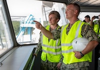 Two members of leadership point out a window while having a conversation.