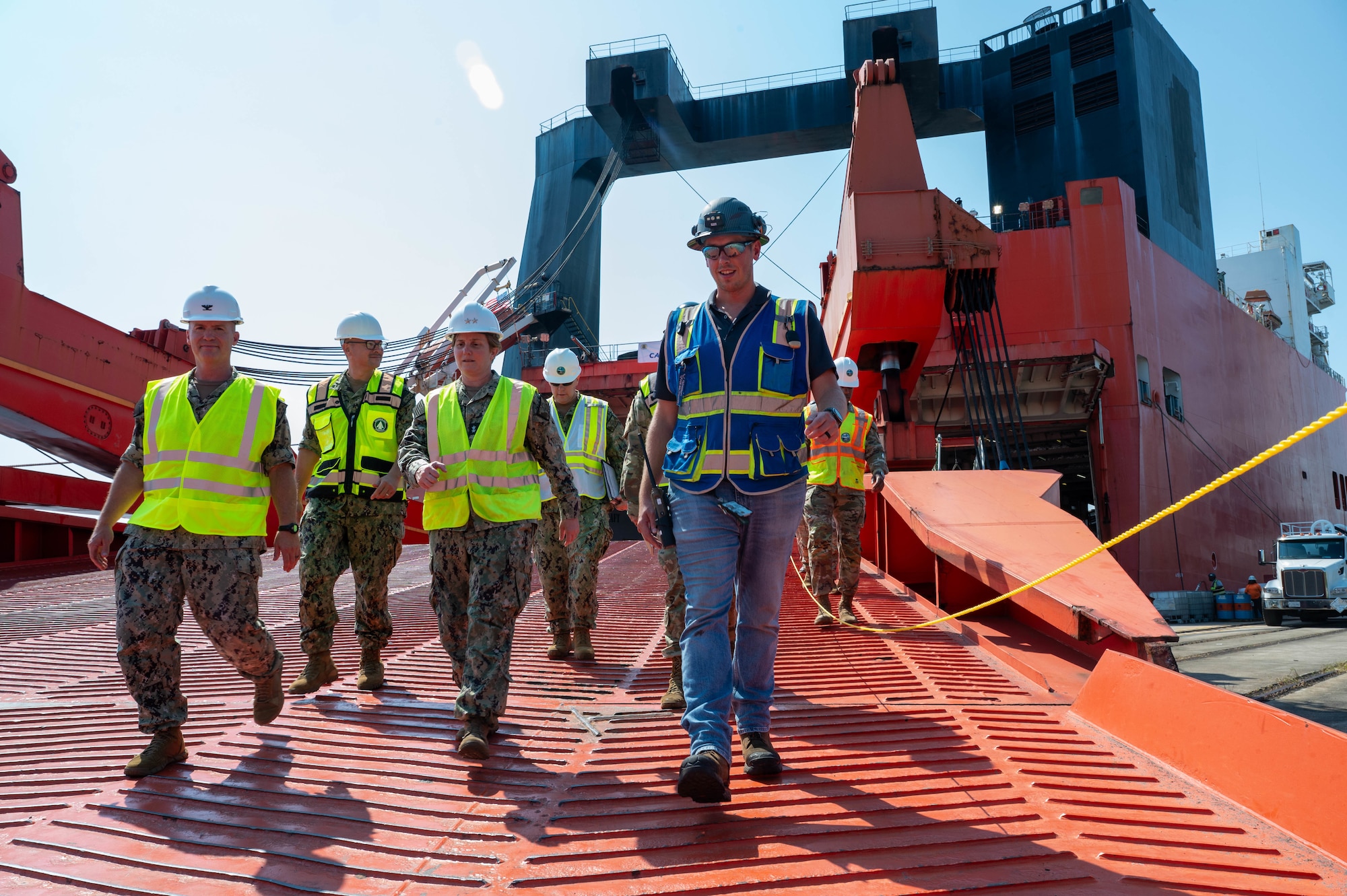 A group of people walk out of a cargo ship.