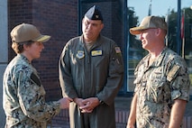 Three members of leadership have a conversation outside of a building.