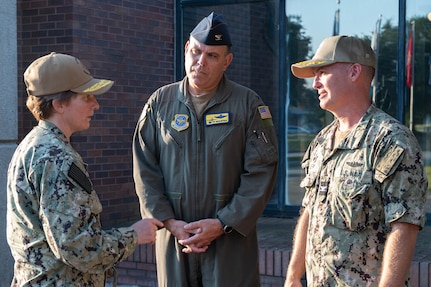 Three members of leadership have a conversation outside of a building.