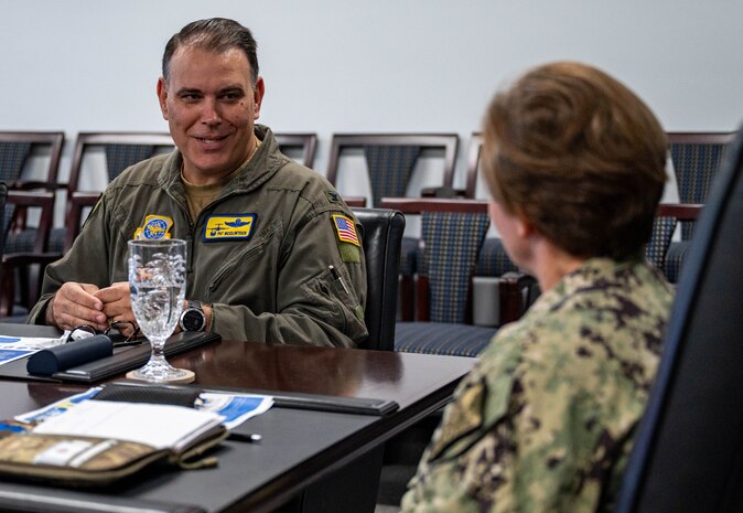 Members of leadership have a conversation at a conference table.
