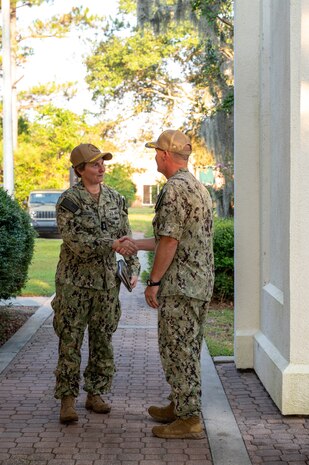 Leadership greet each other outside of a building before the start of a tour