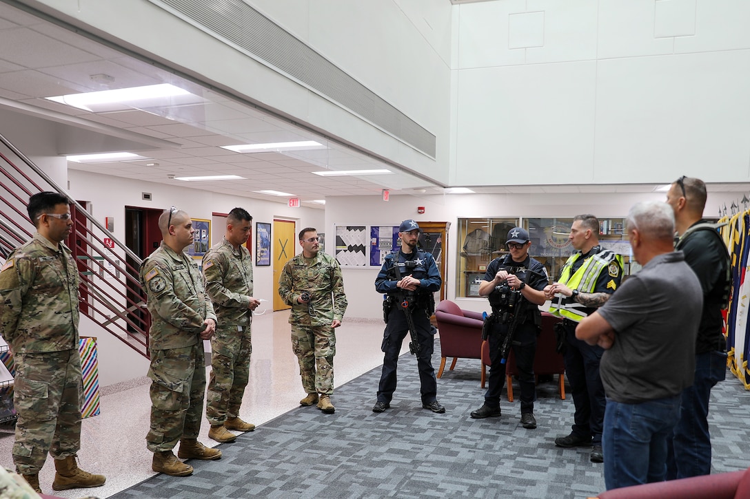 Sgt. Patrick Chojnowski, in yellow vest, a sergeant assigned to the Arlington Heights Police Department, gives a safety brief to members of the 85th U.S. Army Reserve Support Command during an active shooter training exercise at the 85th USARSC headquarters, September 6, 2025.