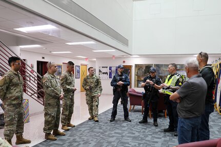 Sgt. Patrick Chojnowski, in yellow vest, a sergeant assigned to the Arlington Heights Police Department, gives a safety brief to members of the 85th U.S. Army Reserve Support Command during an active shooter training exercise at the 85th USARSC headquarters, September 6, 2025.