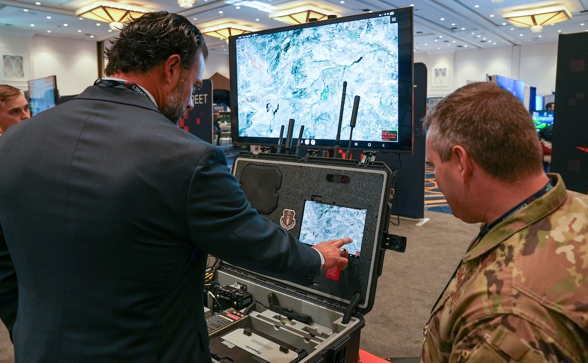 Master Sgt. Matt Workoff, AFWERX Spark, briefs Matthew Lohmeier, Under Secretary of the Air Force, during the Air, Space and Cyber Conference at the Gaylord National Resort and Convention Center in National Harbor, Maryland, on Sept. 23, 2025.