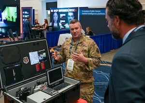 Master Sgt. Matt Workoff, AFWERX Spark, briefs Matthew Lohmeier, Under Secretary of the Air Force, during the Air, Space and Cyber Conference at the Gaylord National Resort and Convention Center in National Harbor, Maryland, on Sept. 23, 2025.
