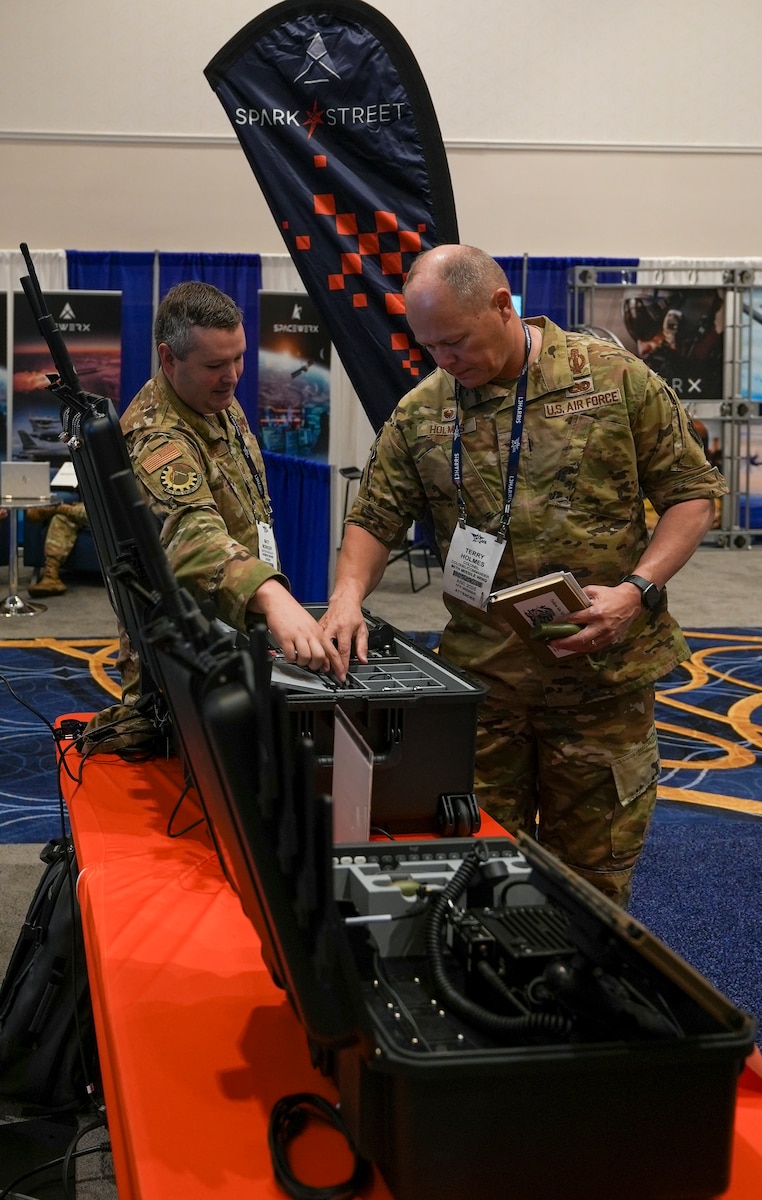 Master Sgt. Matt Workoff, AFWERX Spark, briefs Col. Terry Holmes, 90th Missile Wing commander, during the Air, Space and Cyber Conference at the Gaylord National Resort and Convention Center in National Harbor, Maryland, on Sept. 23, 2025.