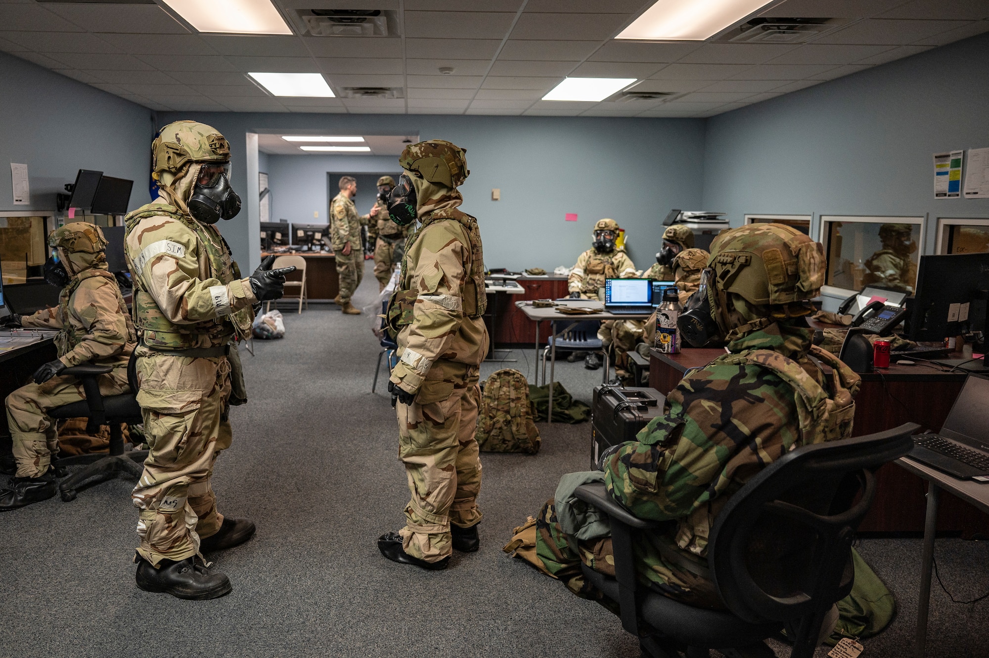 U.S. Air Force Airmen assigned to the 23rd Air Task Force and 723rd Combat Air Base Squadron, wear mission-oriented protective posture level four gear while working in the operations center during a field training exercise at the Silver Flag Exercise Site on Tyndall Air Force Base, Fla., Sept. 18, 2025. The Airmen donned protective gear during a simulated chemical attack.