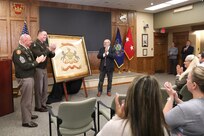 A ceremony marks the return of a historic flag from more than 100 years ago to Pennsylvania National Guard headquarters September 29, 2025, at Fort Indiantown Gap, Pennsylvania. Joseph Reselli, an electrician and lifelong Pennsylvanian who purchased the flag and donated it, presented the flag to Maj. Gen. John R. Pippy, Pennsylvania’s adjutant general, and Command Sgt. Maj. Shawn Phillips, command senior enlisted advisor. It is believed to date from 1920-21, soon after the National Defense Act of 1920 reorganized the U.S. armed forces and formally designated the National Guard, which had previously been known as militias. (U.S. Army National Guard photo by Zane Craig)