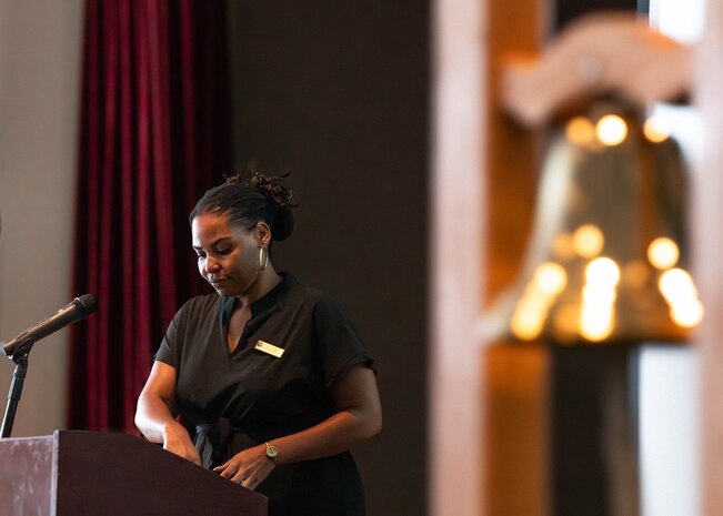 A Master of Ceremony reads from a script at a podium