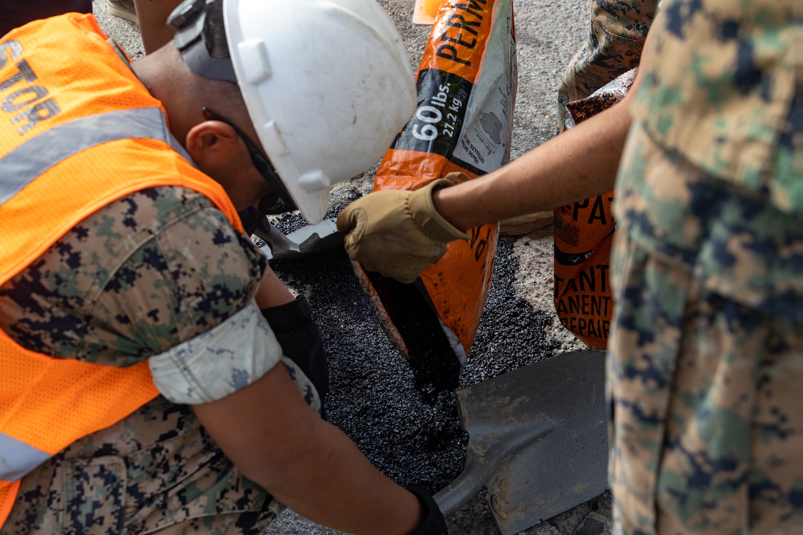 U.S. Marines with I Marine Expeditionary Force, fill in a pothole as part of Operation Clean Sweep on Marine Corps Base Camp Pendleton, California, Sept. 23, 2025. Operation Clean Sweep III, part of the ongoing Barracks 360 Reset initiative, demonstrates a collective commitment to improving living conditions through shared ownership, sustained accountability, and tangible improvements to the barracks. (U.S. Marine Corps photo by Lance Cpl. Stella Tedesco)