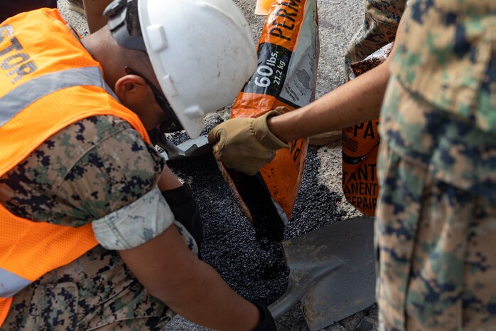 U.S. Marines with I Marine Expeditionary Force, fill in a pothole as part of Operation Clean Sweep on Marine Corps Base Camp Pendleton, California, Sept. 23, 2025. Operation Clean Sweep III, part of the ongoing Barracks 360 Reset initiative, demonstrates a collective commitment to improving living conditions through shared ownership, sustained accountability, and tangible improvements to the barracks. (U.S. Marine Corps photo by Lance Cpl. Stella Tedesco)