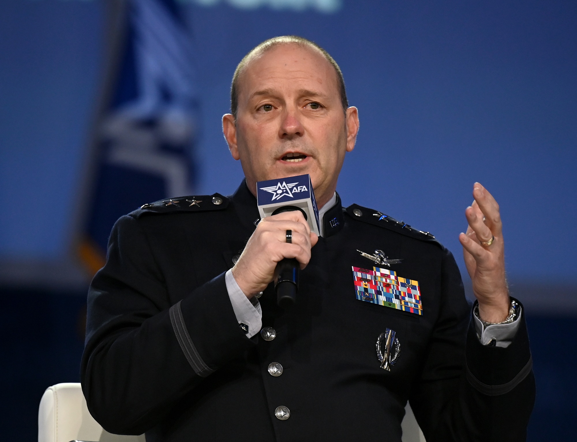 A military general speaks in to a microphone at a conference.