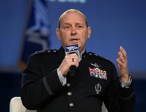 A military general speaks in to a microphone at a conference.