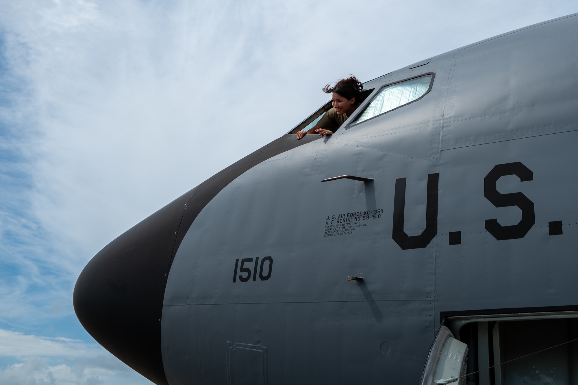 a military pilot sticks her head out of a KC-135 cockpit window