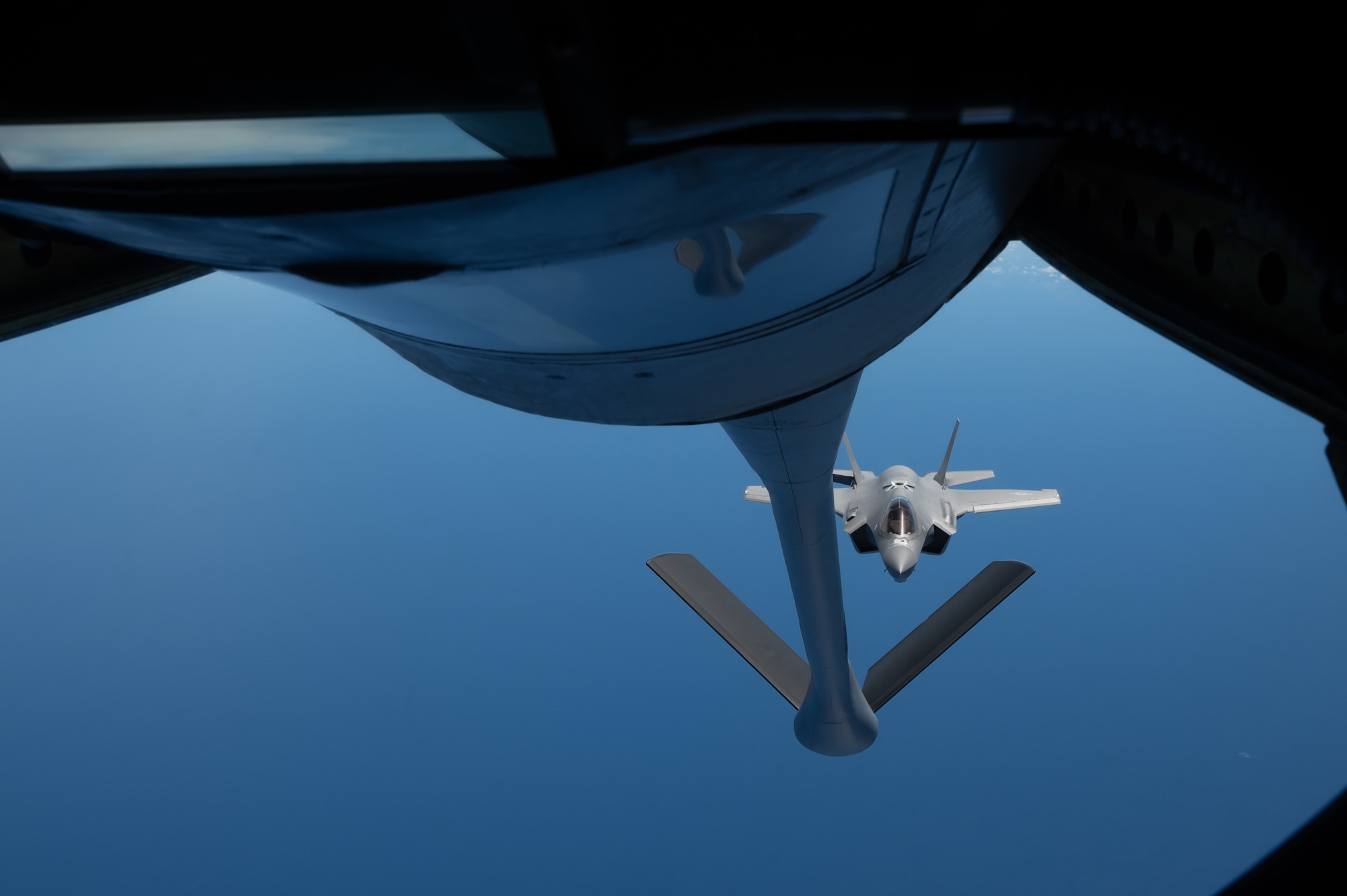 A F-35 jet flies behind a KC-135 before it gets refueled