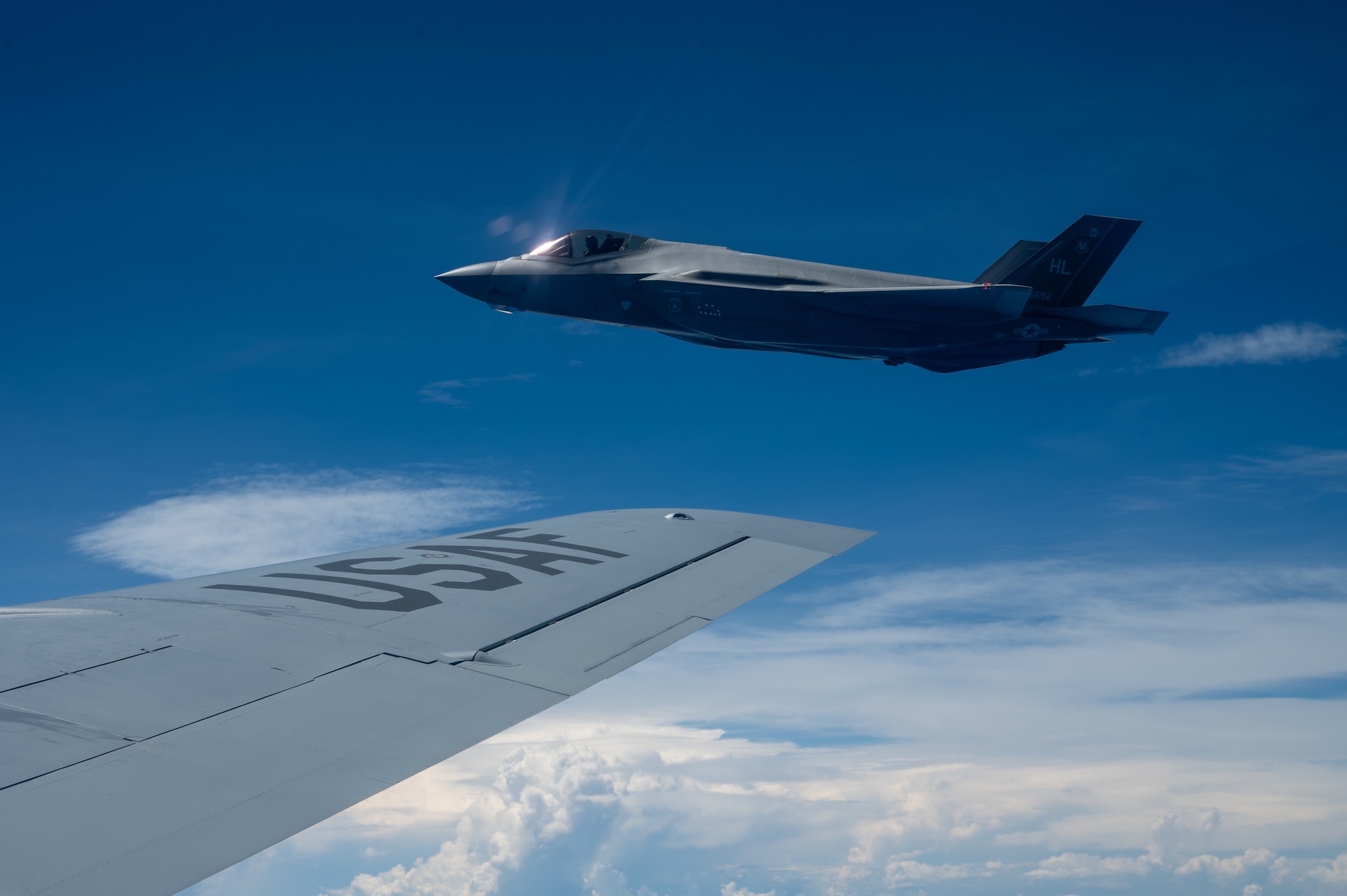 a F-35A Lightning II jet flies next to the wing of a KC-135