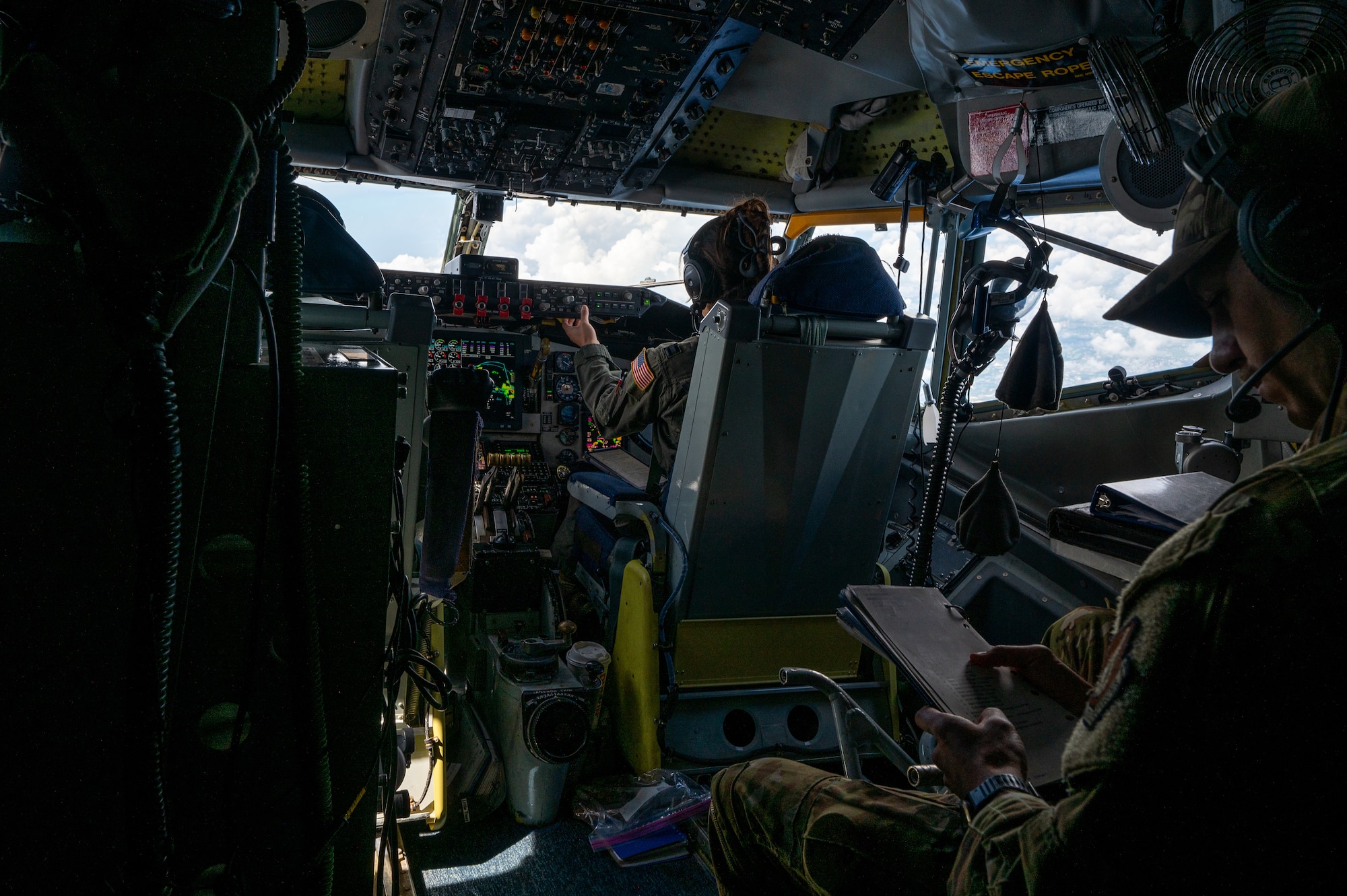 air crew sit in the cockpit of a KC-135 while flying