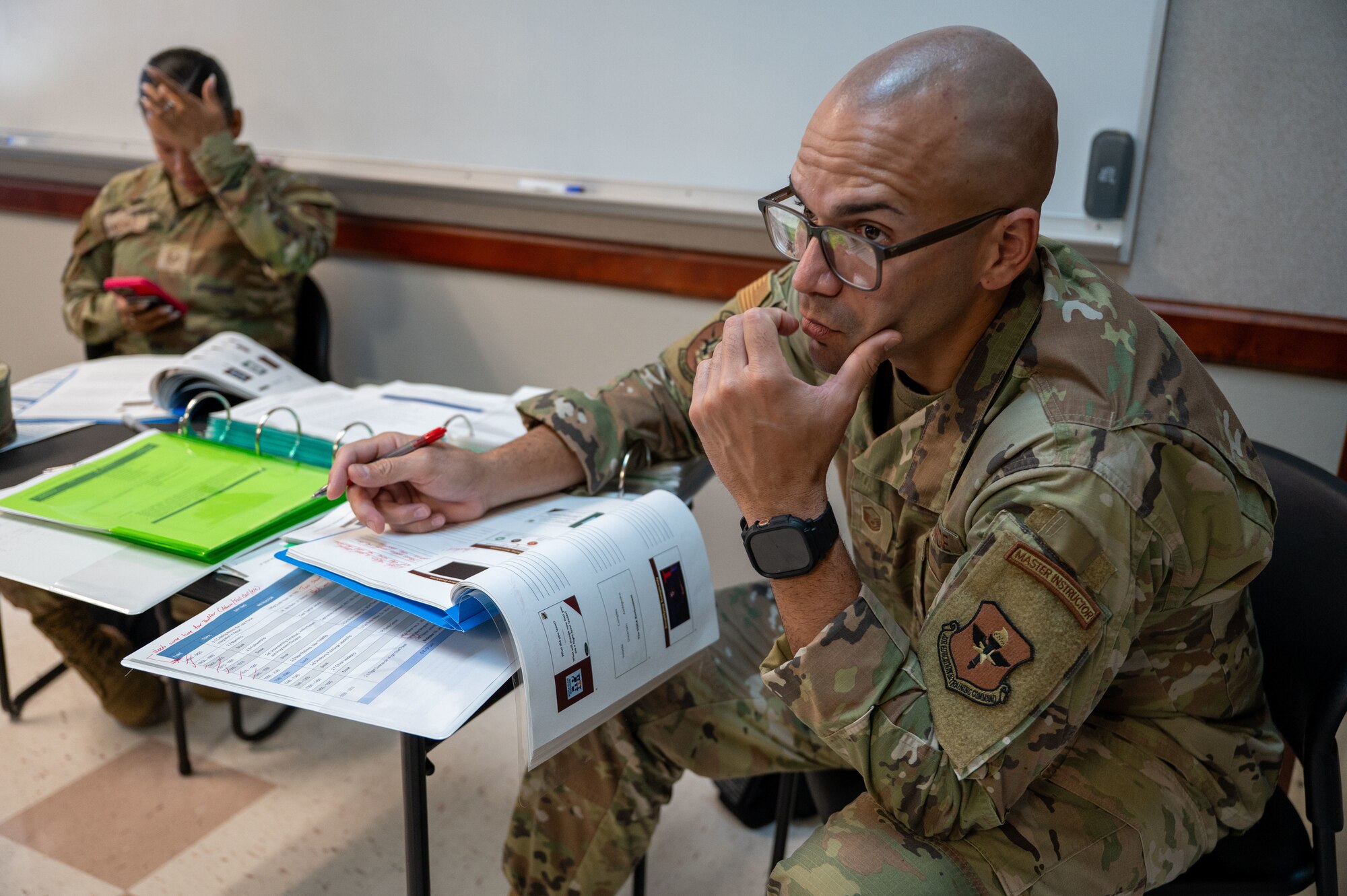 Master Sergeant Jesus Cintron takes notes while looking at instructor who is out-of-frame