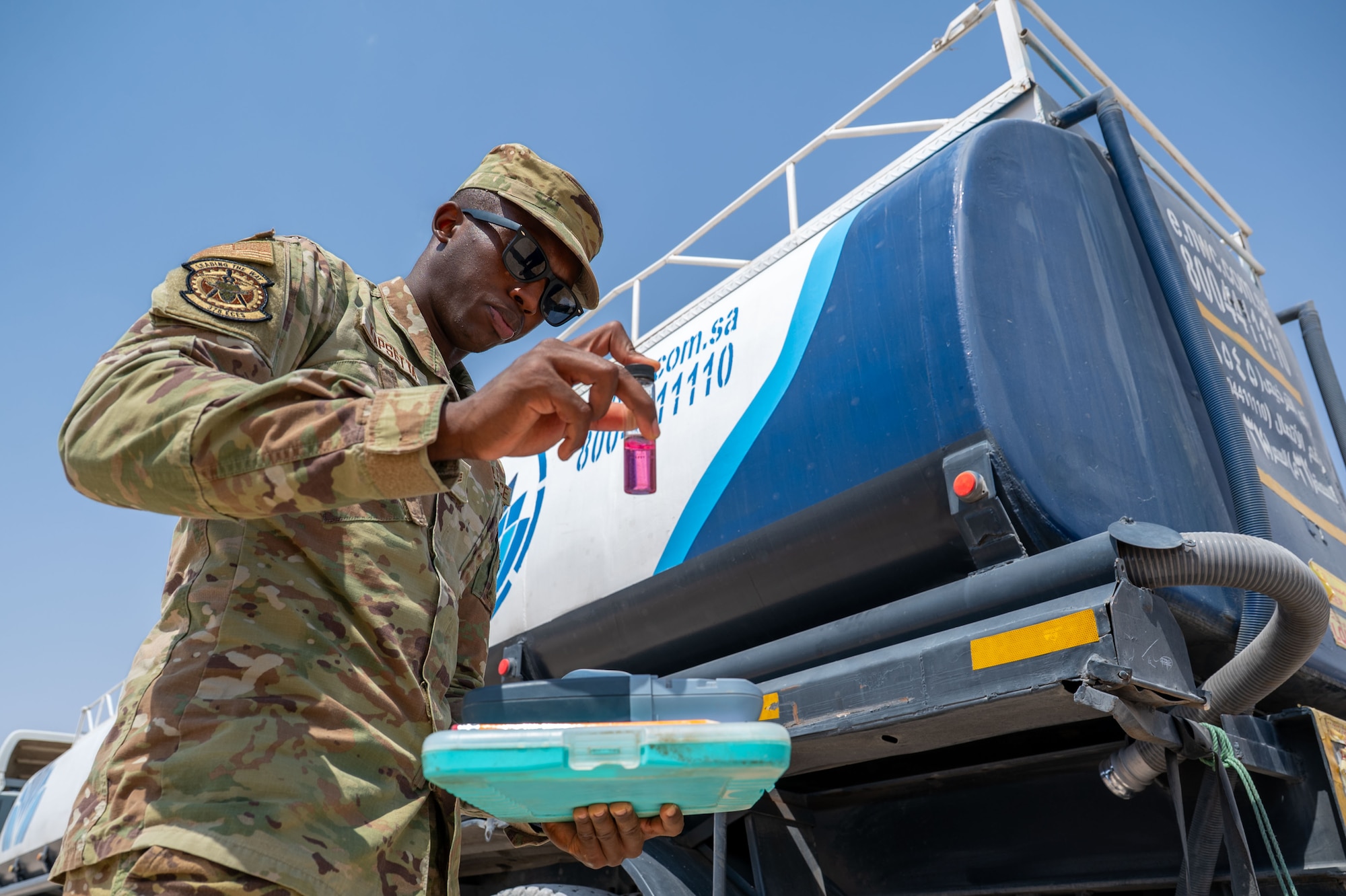 U.S. Air Force Senior Airman Daniel Kapsetta, 378th Expeditionary Civil Engineer Squadron water and fuel systems maintenance journeyman, examines a water sample from a delivery truck.