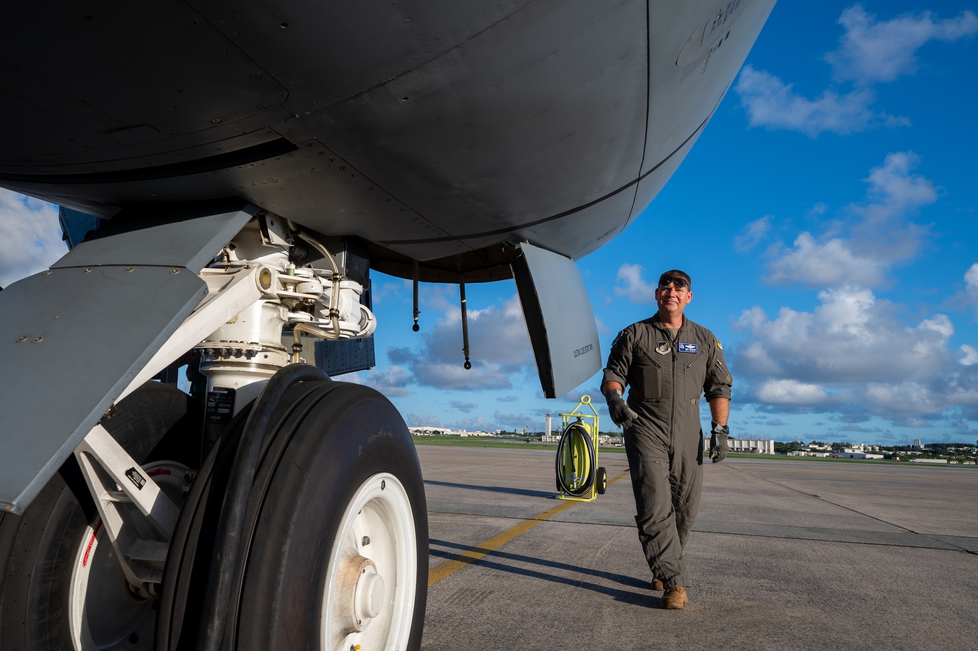 Air Force pilot walks next to a KC-135 front wheel