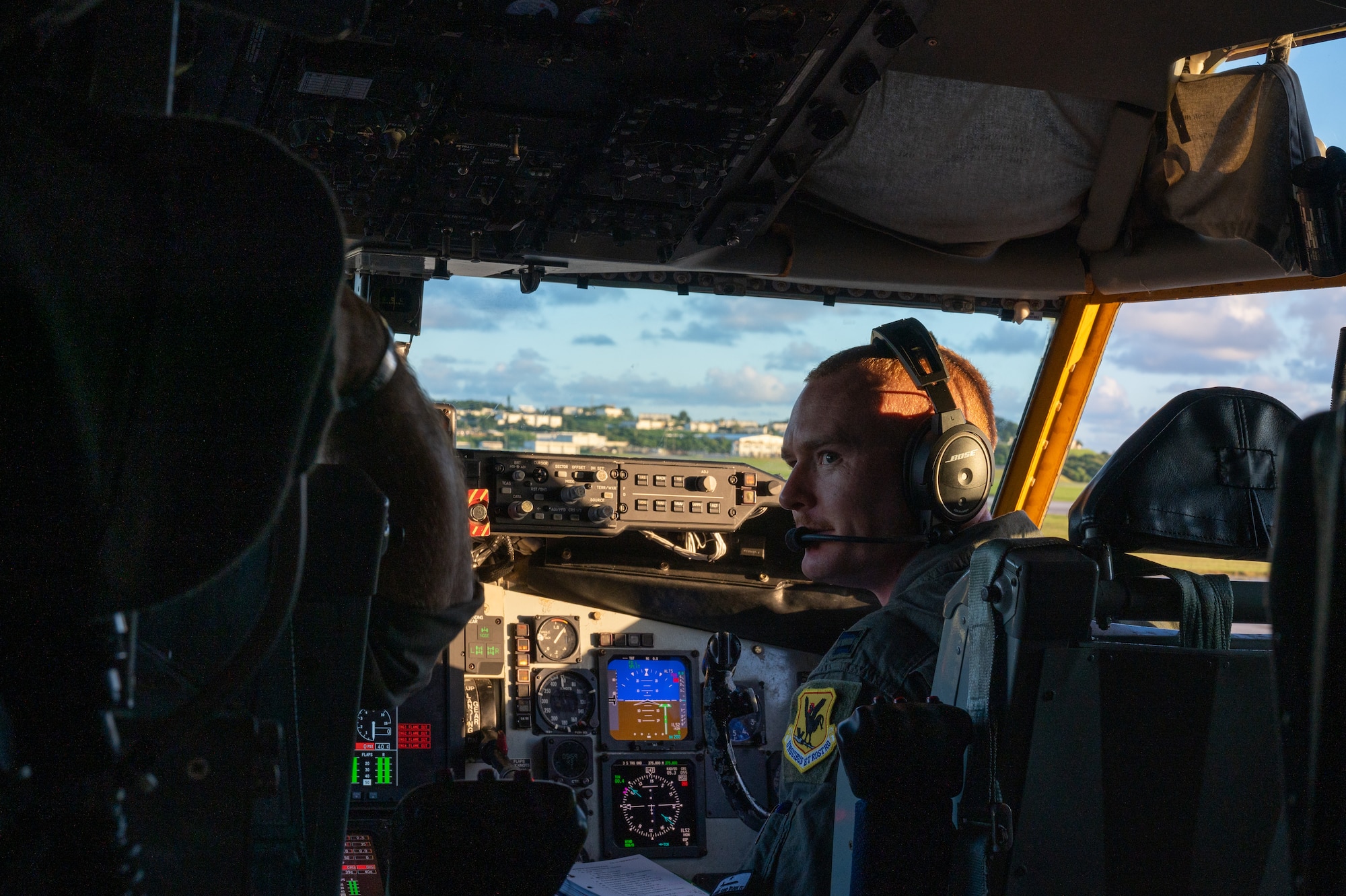 pilot sits in the cockpit while in orange light from a sunset