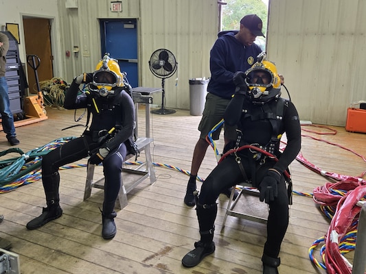 NIANTIC, Conn. (Sept. 24, 2025) Navy Dive Medical Technician 1st Class Spencer Warren inspects the dive helmet as the Naval Submarine Medical Research Laboratory (NSMRL) dive team prepares for a dive at Dodge Pond, where they worked for over five weeks assisting with a research protocol on underwater hearing. NSMRL, part of Navy Medicine Research & Development and based out of Groton, Connecticut, sustains the readiness and superiority of U.S. undersea warfighters through innovative health and performance research and works to lead the world in delivering science solutions to ensure undersea warrior dominance. For 250 years, Navy Medicine, represented by more than 44,000 highly-trained military and civilian healthcare professionals, has delivered quality healthcare and enduring expeditionary medical support to the warfighter on, below, and above the sea and ashore. (U.S. Navy photo by Louise Deflice /Released)