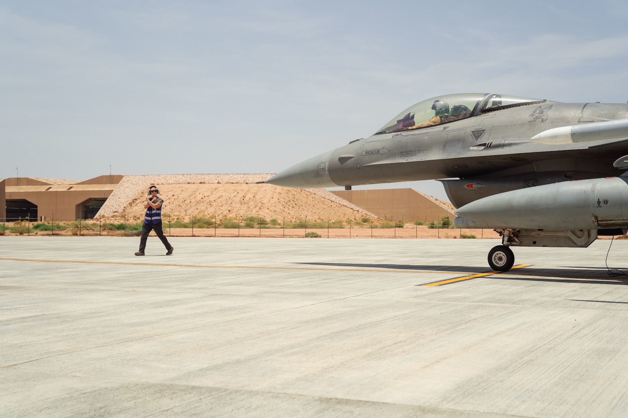 U.S. Air Force Staff Sgt. Sage Timbrel, 55th Expeditionary Fighter Generation Squadron dedicated crew chief, marshals an F-16 Fighting Falcon to prepare for a simulated integrated combat turn.