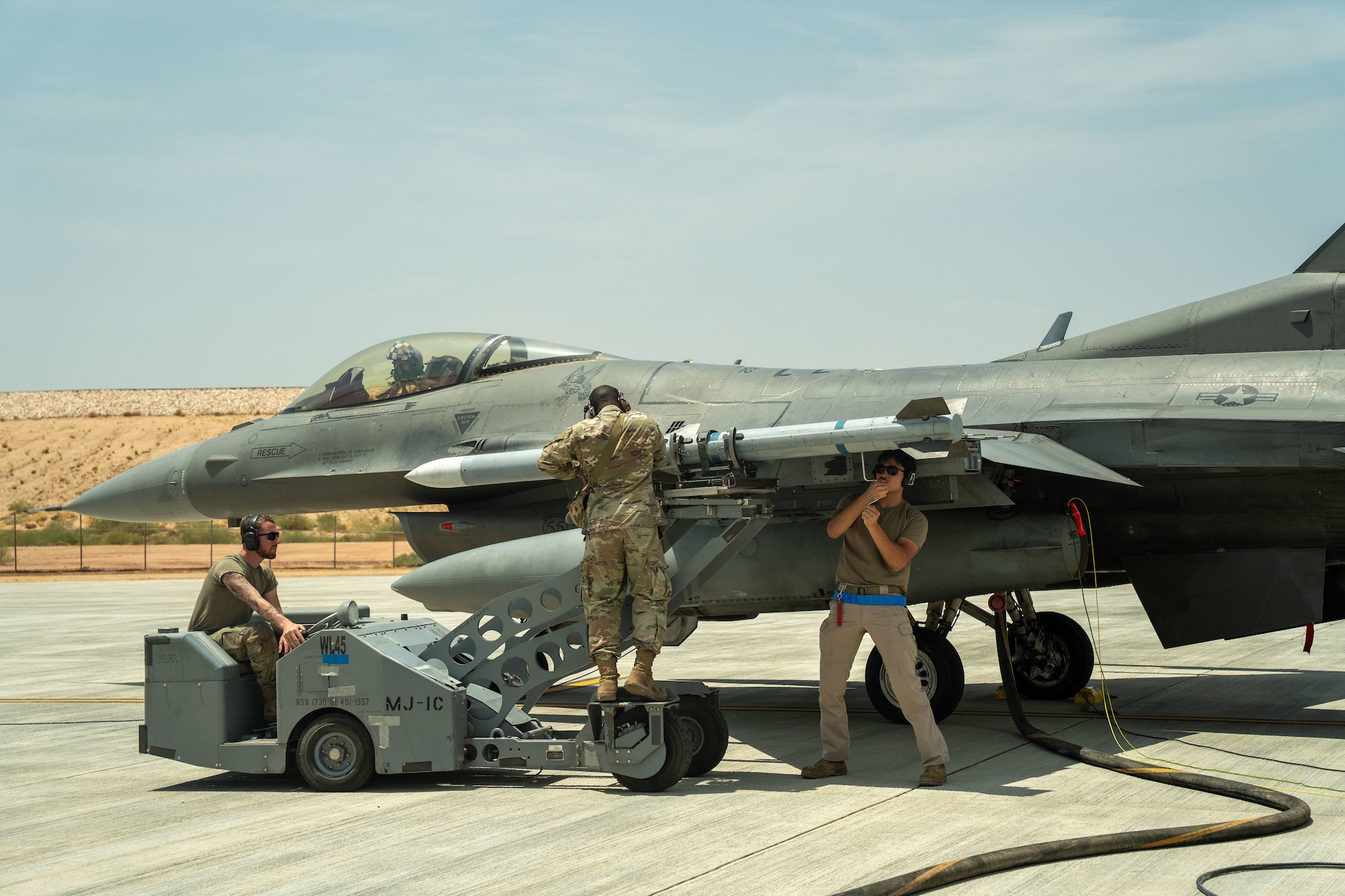 From left, U.S. Air Force Senior Airman Matthew Rannazzisi Kozicki, weapons load crew member, Staff Sgt. Donyea Lackey, weapons load crew chief, and Airman 1st Class Antonio Torres, weapons load crew member, all assigned to the 55th Expeditionary Fighter Generation Squadron, conduct a simulated integrated combat turn.