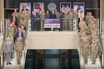 Worldwide Logistics Symposium participants are posed for a group photo across two staircases