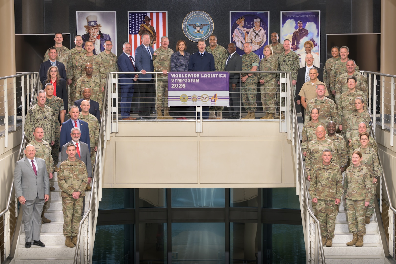 Worldwide Logistics Symposium participants are posed for a group photo across two staircases