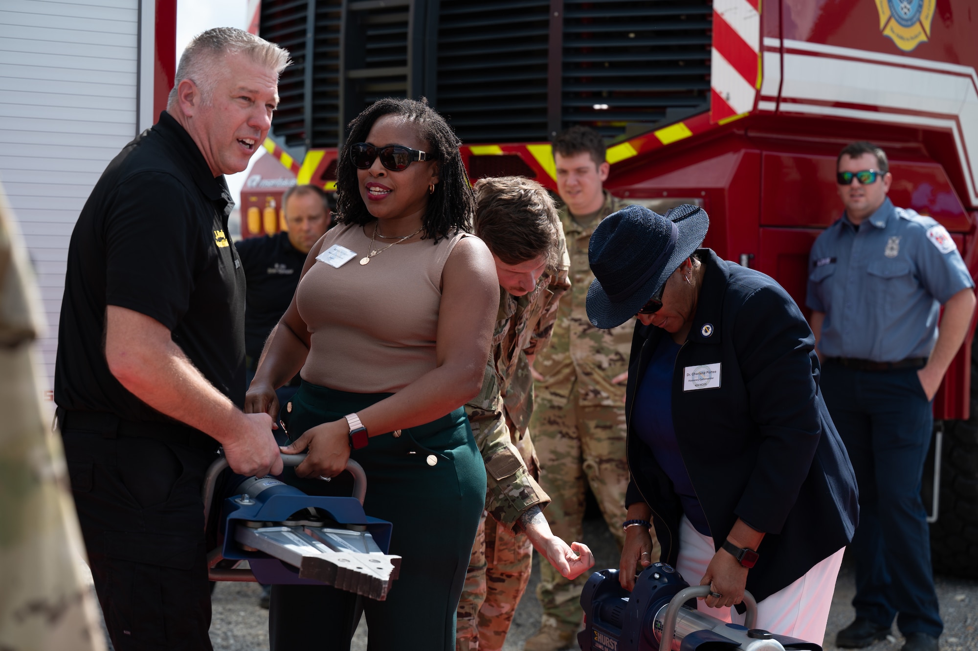 John Bailey, assistant fire chief, 42d Civil Engineer Squadron, provides a demonstration of equipment used by Maxwell's fire department to Ashley Jernigan, honorary commander emeritus, and Dr. Charlene Portee, honorary commander, 42d Health Care Operations Squadron, Sept. 29, 2025.  Throughout the day, the honorary commanders and civic leaders engaged directly with Airmen, asking questions and gaining new insights into their responsibilities, challenges and achievements. (U.S. Air Force photo by Senior Airman Evan Porter)