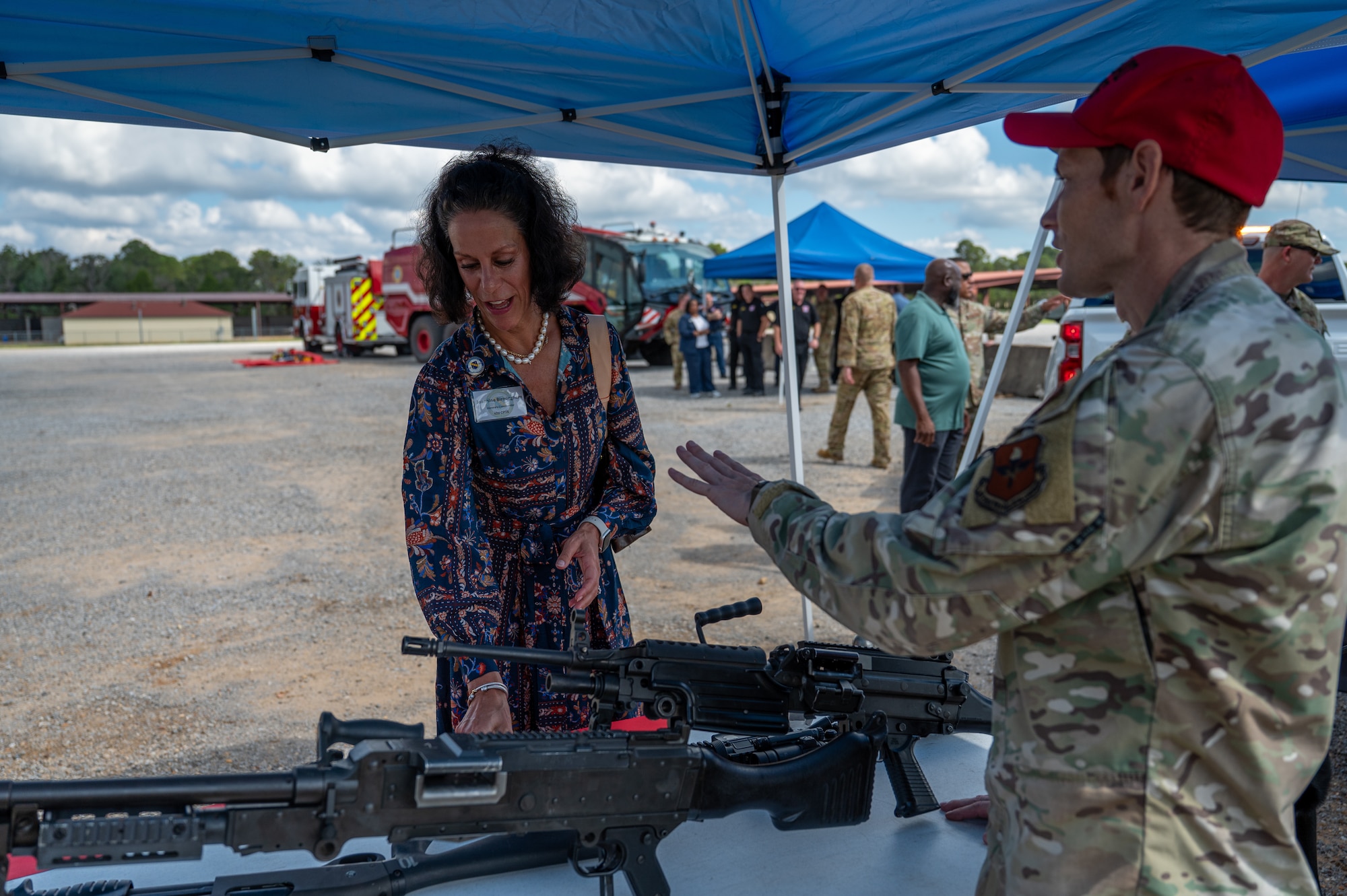 U.S. Air Force Tech. Sgt. Jacob O’Dowd, combat arms instructor, 42d Security Forces Squadron, gives a brief on various firearms to Jeannine Birmingham, honorary commander, 42d Comptroller Squadron, during a tour at Maxwell Air Force Base, Ala., Sept. 29, 2025. As part of the tour, the honorary commanders and civic leaders got the chance to interact with defenders and discover the base's protective measures. (U.S. Air Force photo by Senior Airman Evan Porter)