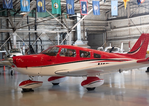 A red plane inside of a hangar