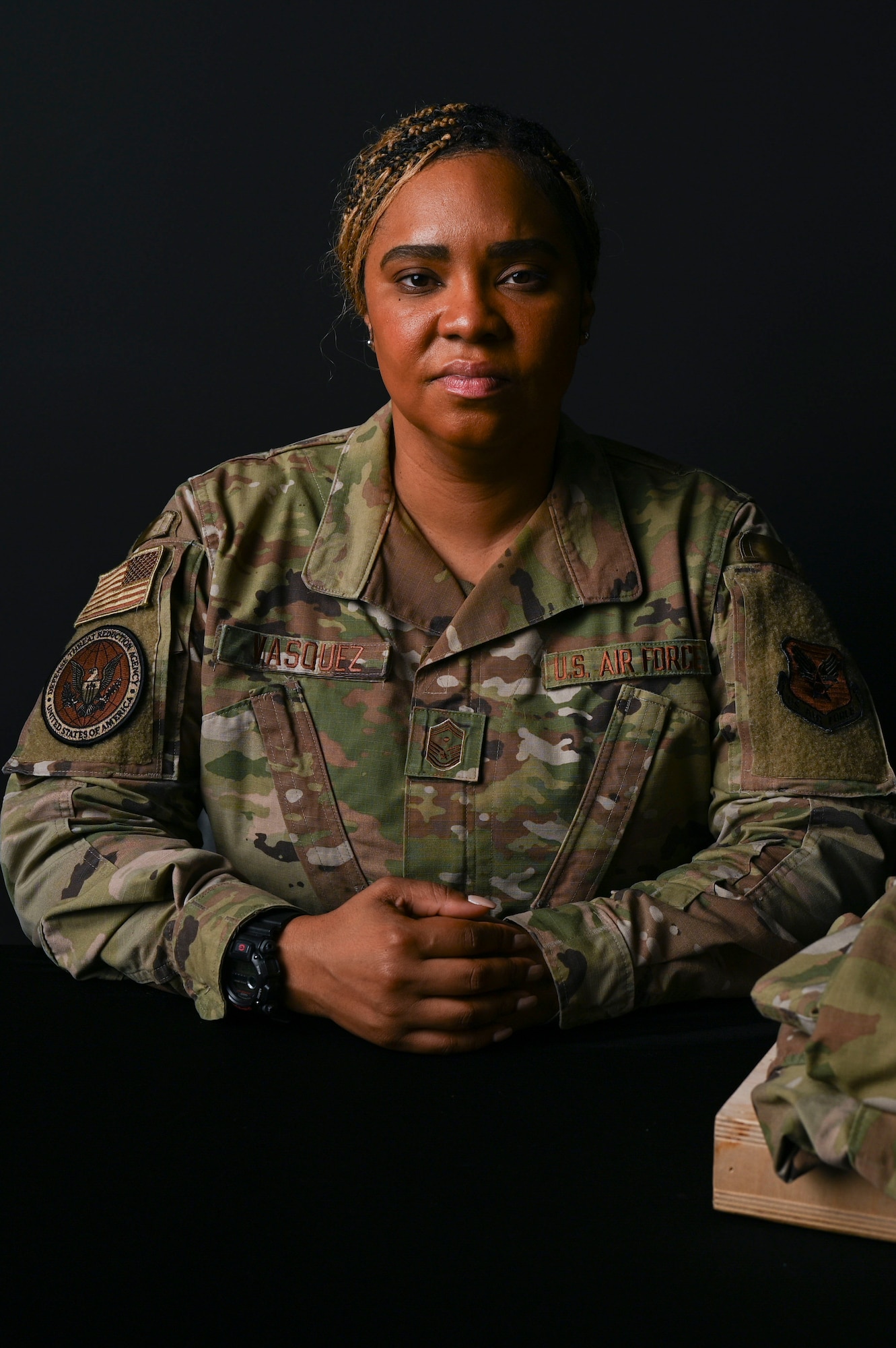 U.S. Air Force Senior Master Sergeant Capri Vasquez, first sergeant for the Defense Threat Reduction Agency at Fort Belvoir, poses with a uniform honoring her fallen Airman at Joint Base Anacostia-Bolling, Washington, D.C., Sept. 10, 2025. Her Airman died by suicide on November 18, 2021 and this photoshoot was conducted in honor of National Suicide Prevention Awareness Month, which has been observed each September since 2008. (U.S. Air Force photo by Airman 1st Class Shanel Toussaint)