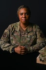 U.S. Air Force Senior Master Sergeant Capri Vasquez, first sergeant for the Defense Threat Reduction Agency at Fort Belvoir, poses with a uniform honoring her fallen Airman at Joint Base Anacostia-Bolling, Washington, D.C., Sept. 10, 2025. Her Airman died by suicide on November 18, 2021 and this photoshoot was conducted in honor of National Suicide Prevention Awareness Month, which has been observed each September since 2008. (U.S. Air Force photo by Airman 1st Class Shanel Toussaint)
