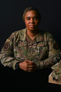 U.S. Air Force Senior Master Sergeant Capri Vasquez, first sergeant for the Defense Threat Reduction Agency at Fort Belvoir, poses with a uniform honoring her fallen Airman at Joint Base Anacostia-Bolling, Washington, D.C., Sept. 10, 2025. Her Airman died by suicide on November 18, 2021 and this photoshoot was conducted in honor of National Suicide Prevention Awareness Month, which has been observed each September since 2008. (U.S. Air Force photo by Airman 1st Class Shanel Toussaint)