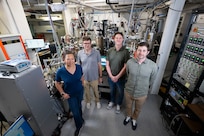 Members of the Quantum Materials and Spintronics team gather for a group photo in front of a cluster system in Washington, D.C., Sept. 18, 2025. The team uses the cluster system to synthesize new quantum materials with potential for impactful Navy applications in memory storage, advanced sensors, and energy-efficient electronics. (U.S. Navy photo by Sarah Peterson)
