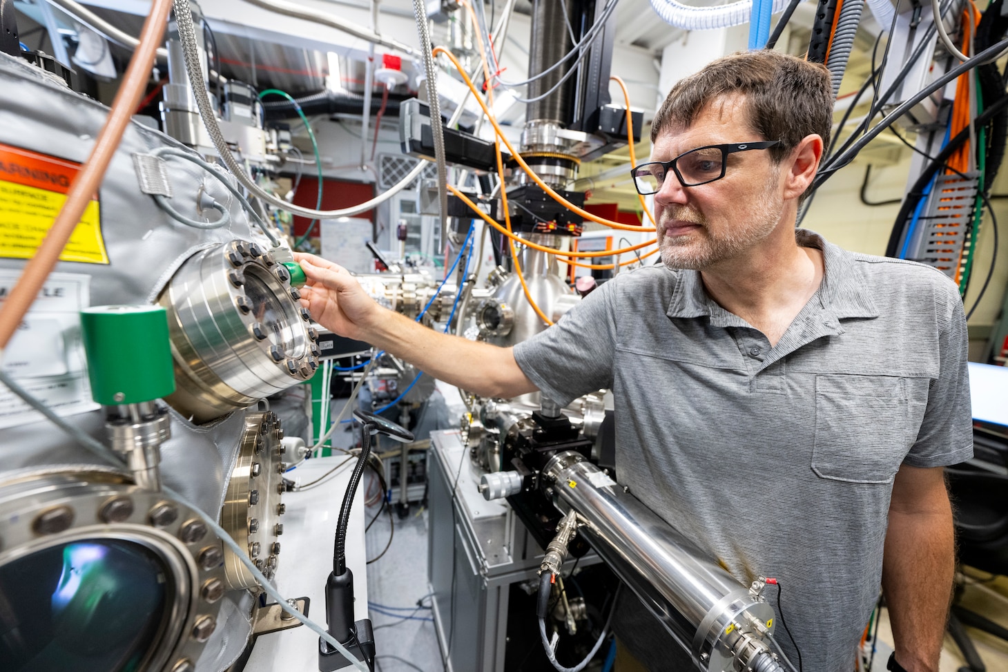 Olaf Van T Erve, Ph.D., U.S. Naval Research Laboratory scientist, monitors the sputter deposition process of magnetic thin films in a cluster system in Washington, D.C., Sept. 18, 2025. Van T Erve uses the cluster system to grow and characterize quantum materials for the fabrication of nanoscale devices with unique functionalities. (U.S. Navy photo by Sarah Peterson)