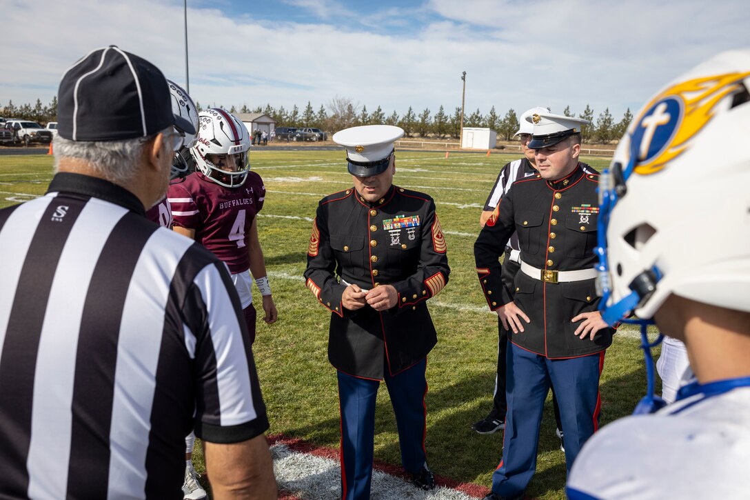 U.S. Marine Corps Sgt. Maj. Pablo Alarcon, Sergeant Major for Recruiting Station Albuquerque, flips a coin during the coin toss  for the Melrose High School Vs. Mesilla Valley Christian School football game at Melrose High School in Melrose, New Mexico, Nov. 23, 2024. Marines with Recruiting Station Albuquerque had the opportunity to conduct the coin toss at the beginning of the game, as well as hold a recruiting booth to provide more information about service in the Marine Corps. (U.S. Marine photo by Sgt. Mark A. Morales)