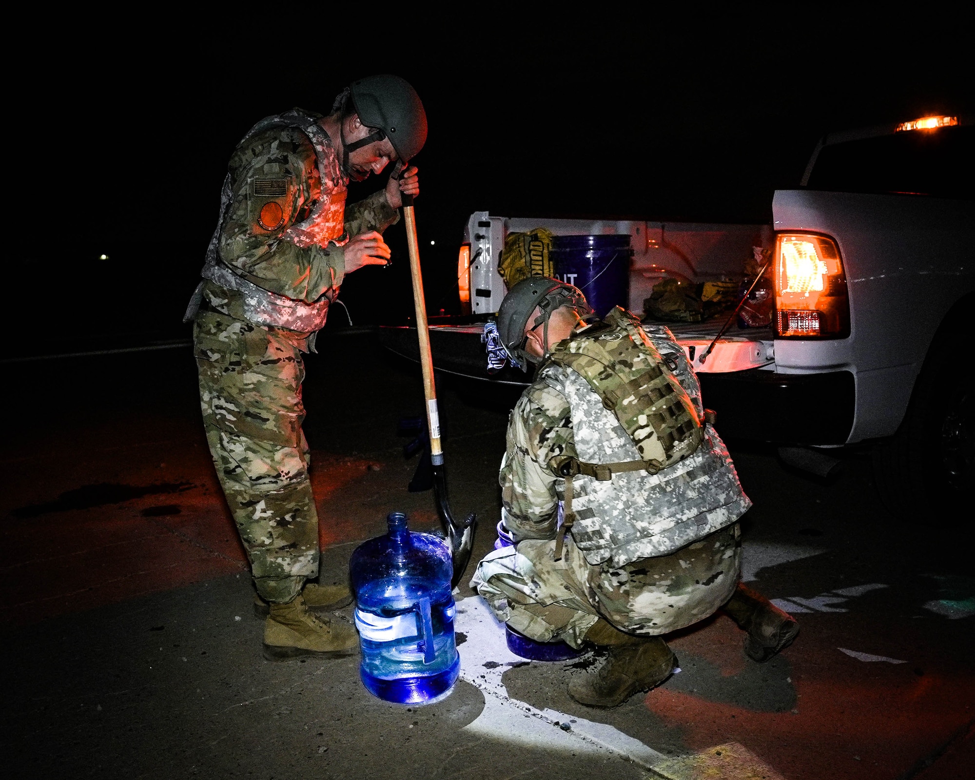 U.S. Air Force Senior Airmen John Zorumski (left), 56th Equipment Maintenance Squadron Aerospace Ground Equipment specialist, and Frank Thomas (right), 63rd Aircraft Maintenance Unit crew chief, mix concrete to repair a section of the runway during an Ability to Survive and Operate overnight field exercise