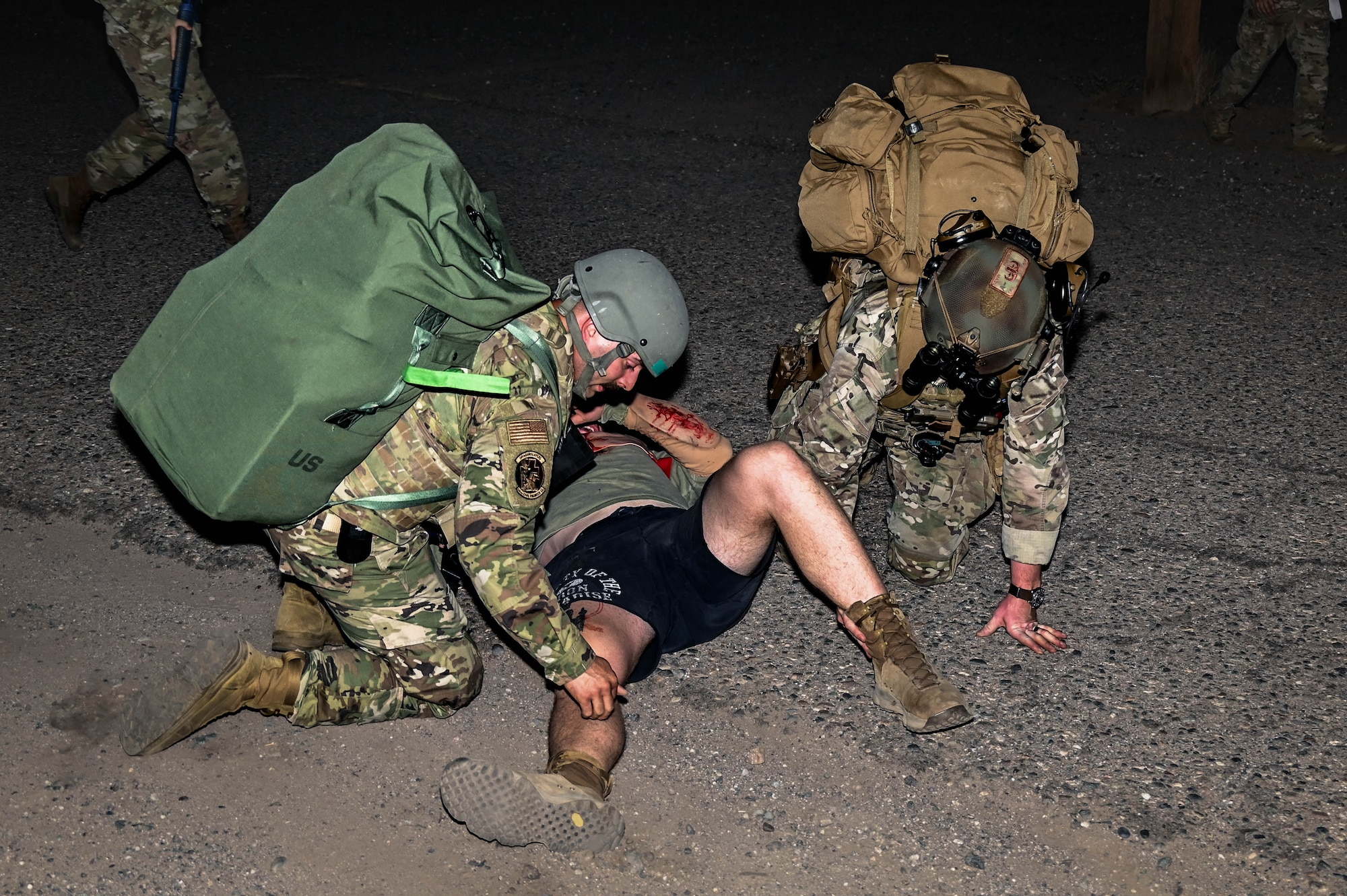 U.S. Air Force Staff Sgt. Oscar Marquez (left), 607th Air Control Squadron Heating, Ventilation, and Air Conditioning technician, and Senior Airman Kevin Hodgson (right), 56th Civil Engineer Squadron Explosive Ordnance Disposal technician, apply immediate simulated tactical combat casualty care skills during an Ability to Survive and Operate overnight field exercise
