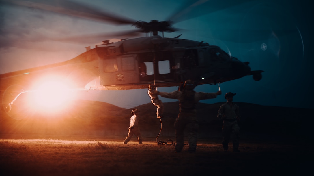 U.S. Marines with the Maritime Raid Force, 11th Marine Expeditionary Unit, fast-rope from a U.S. Navy MH-60S Seahawk with Helicopter Sea Combat Squadron (HSC) 21 during helicopter rope suspension techniques training on Marine Corps Base Camp Pendleton, California, Sept. 17, 2025. The HRST training prepares Marines to navigate difficult terrain and enhance air-to-ground insertion capabilities. (U.S. Marine Corps photo by Cpl. Joseph Helms)